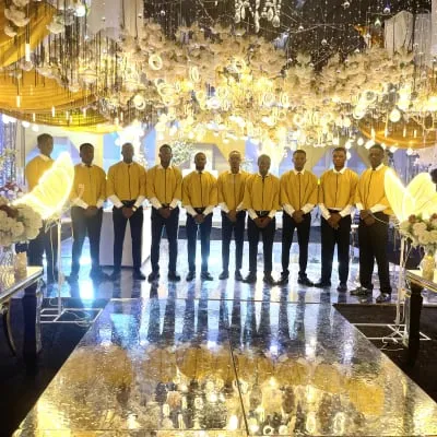 Male ushers in yellow at luxury crystal chandelier ballroom