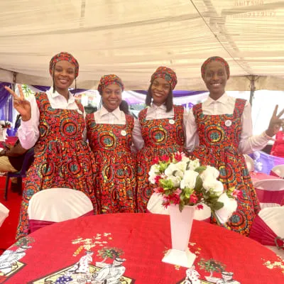 Female usher in red vest at outdoor event