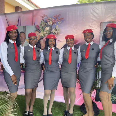 Team in red vests posing in front of Nonytrendz banner